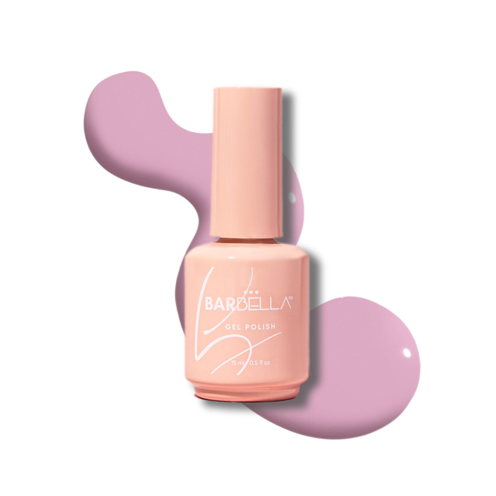 Peach BarBella Co. polish bottle on a swatch of lilac pink polish.